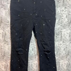 Black distressed denim jeans with rhinestone details and ripped knees